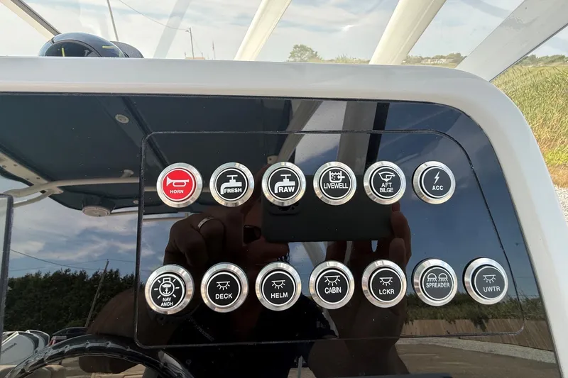Slide: The Image of Control panel of 2025 Edgewater 248CX Crossover boat with various function buttons. - 25