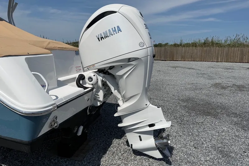 Slide: The Image of 2025 Edgewater 248CX Crossover boat with Yamaha outboard motor on gravel surface. - 7