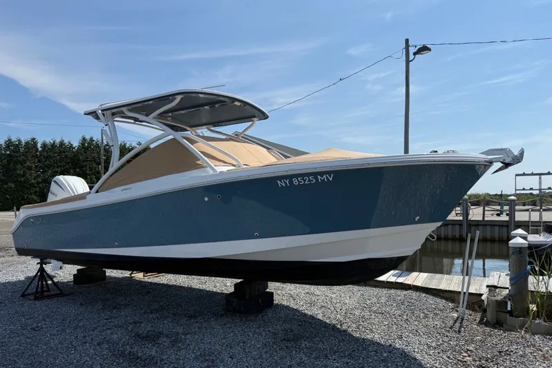 Slide: The Image of 2025 Edgewater 248CX Crossover boat on display at a marina. - 5