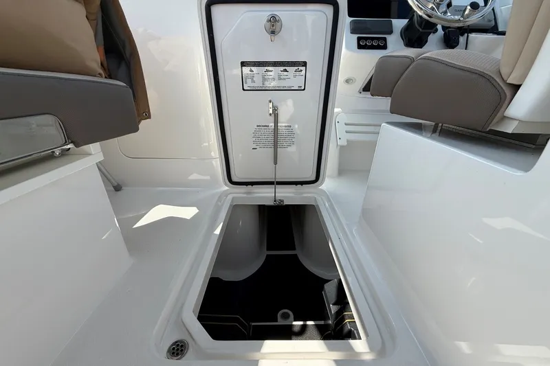 Slide: The Image of 2025 Edgewater 248CX Crossover boat interior with storage compartment open. - 13
