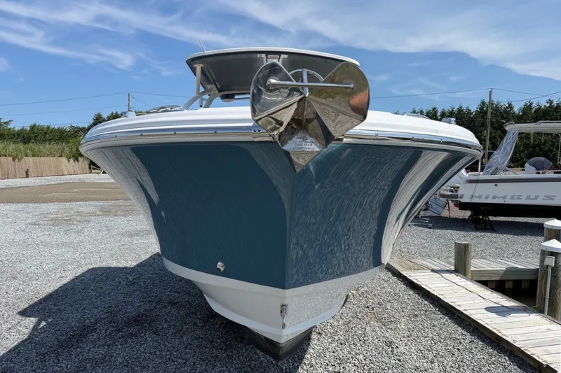 Slide: The Image of 2025 Edgewater 248CX Crossover boat on gravel, showcasing sleek design and modern features. - 6