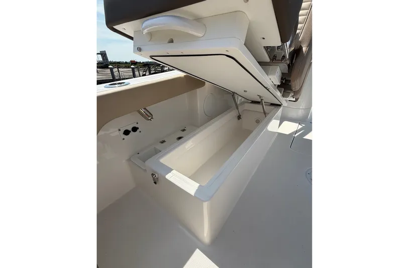 Slide: The Image of 2025 Edgewater 248CX Crossover boat with open storage compartment, showcasing sleek design. - 12