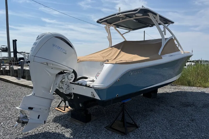 Slide: The Image of 2025 Edgewater 248CX Crossover boat with Yamaha outboard engine, covered and docked. - 3