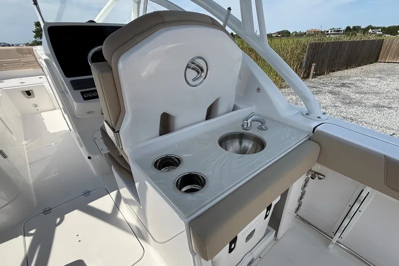 Slide: The Image of 2025 Edgewater 248CX Crossover boat interior with sink and cup holders. - 17