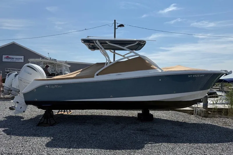 Slide: The Image of 2025 Edgewater 248CX Crossover boat on display at a marina, side view. - 4