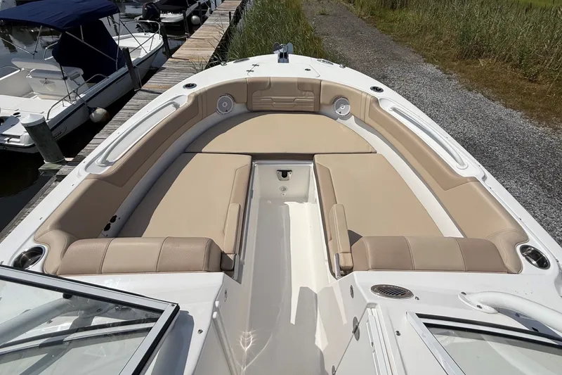 Slide: The Image of 2025 Edgewater 248CX Crossover boat with spacious beige seating at a dock. - 27