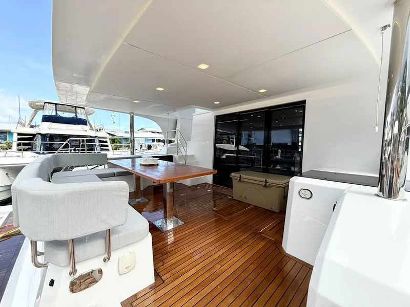 Slide: The Image of Luxurious 2025 Aventura 56 Motor Yacht deck with elegant seating and dining area. - 10