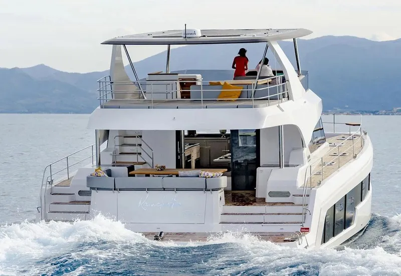Slide: The Image of Aventura 56 Motor Yacht 2025 cruising on open water with passengers enjoying the view. - 2