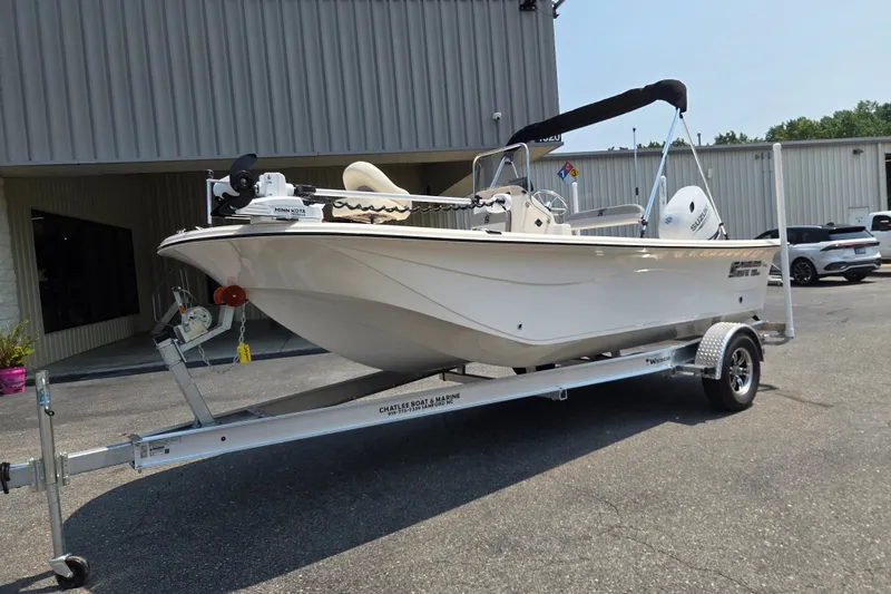 Slide: The Image of 2024 Carolina Skiff 19 LS boat on trailer, parked outside a building. - 1