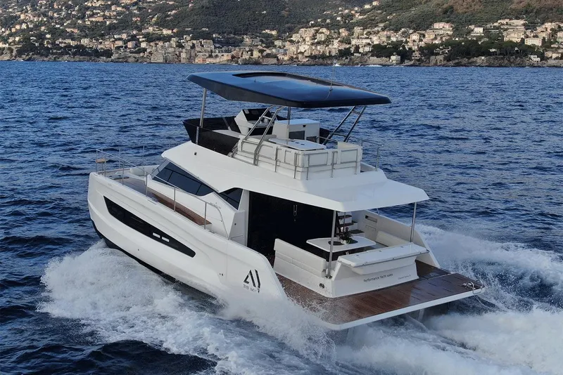Slide: The Image of 2026 Aventura 38 Motor Yacht cruising on the ocean near a coastal town. - 9