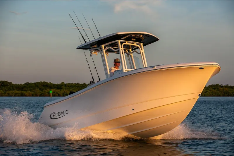 Slide: The Image of Manufacturer Provided Image: 2026 Robalo R232 Explorer boat cruising on water at sunset. - 2