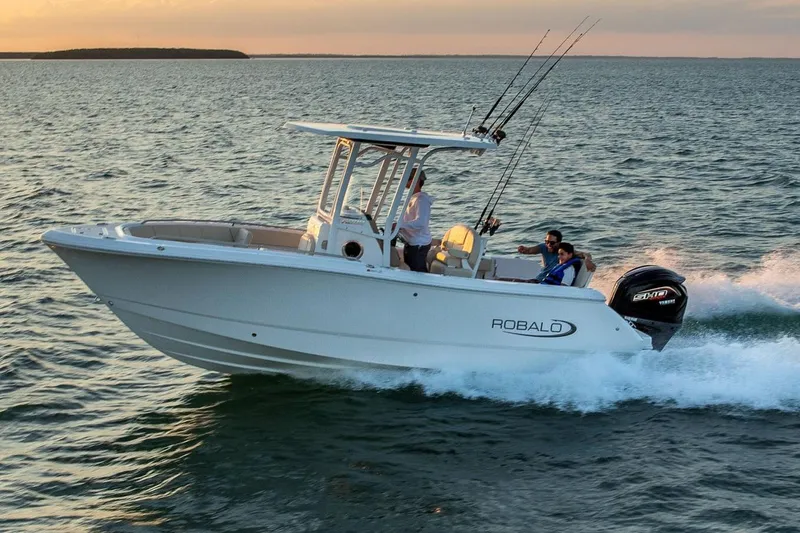 Slide: The Image of Manufacturer Provided Image: 2026 Robalo R232 Explorer boat cruising on open water at sunset. - 1