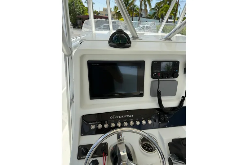 Slide: The Image of 2006 Sailfish 2360 CC boat dashboard with navigation equipment and steering wheel. - 13