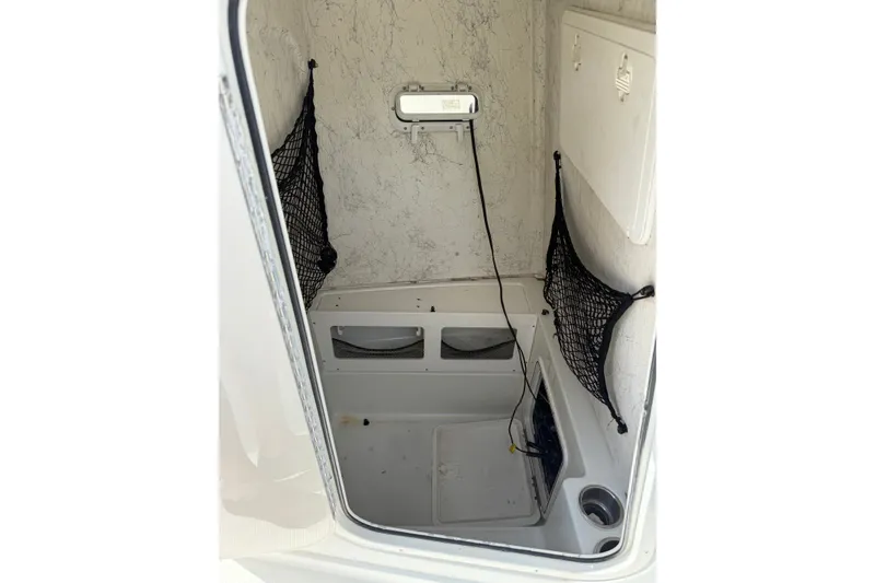 Slide: The Image of Interior view of 2006 Sailfish 2360 CC boat storage compartment with netting and wiring. - 8