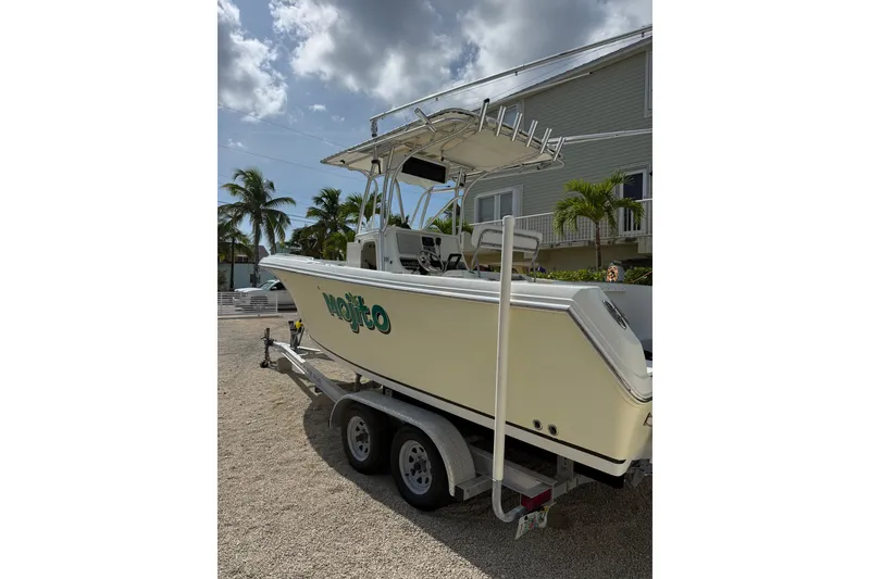 Slide: The Image of 2006 Sailfish 2360 CC boat on trailer, parked near tropical house. - 4