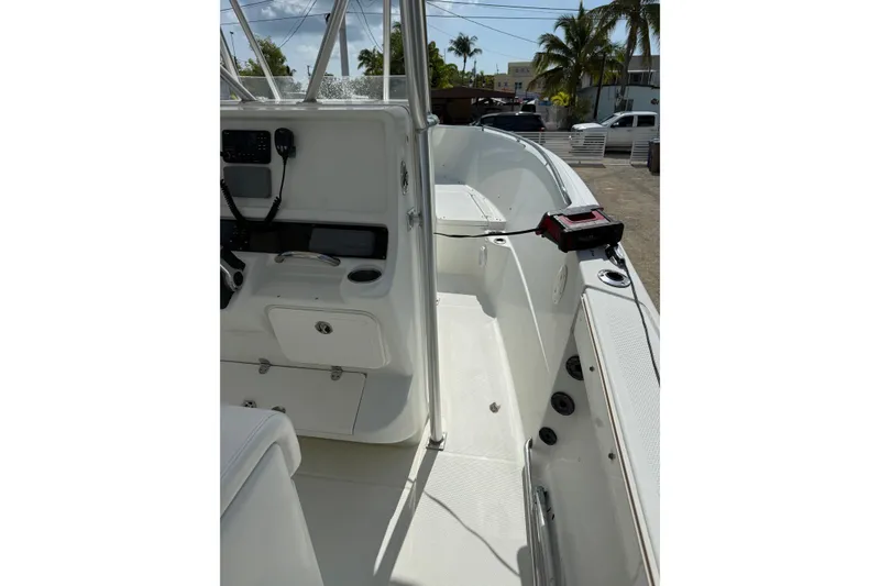 Slide: The Image of 2006 Sailfish 2360 CC boat interior with console and seating, parked outdoors. - 9