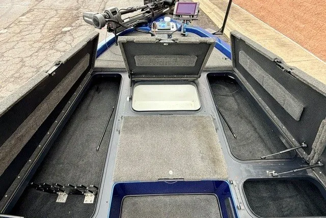 Slide: The Image of 2014 Skeeter TZX195 boat interior with open storage compartments and fishing gear. - 17