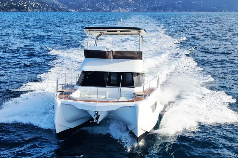 The Image of 2026 Aventura 38 Motor Yacht cruising on open sea with scenic mountain backdrop. - 0