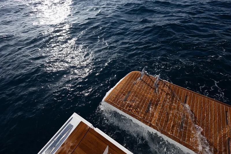 Slide: The Image of Aventura 38 Motor Yacht 2026, wooden deck, ocean view, sunlight reflecting on water. - 17