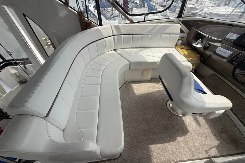 Slide: The Image of Interior of 2000 Carver 396 Motor Yacht with white seating and helm chair. - 12