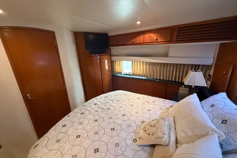 Slide: The Image of Cozy bedroom in 2000 Carver 396 Motor Yacht with elegant wood finishes and TV. - 29