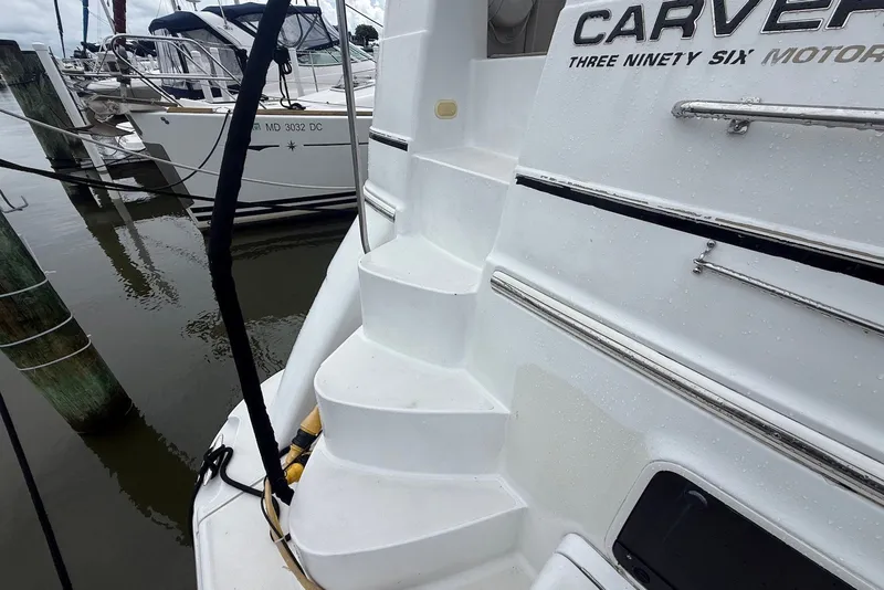 Slide: The Image of 2000 Carver 396 Motor Yacht docked, featuring sleek white steps and polished railings. - 4