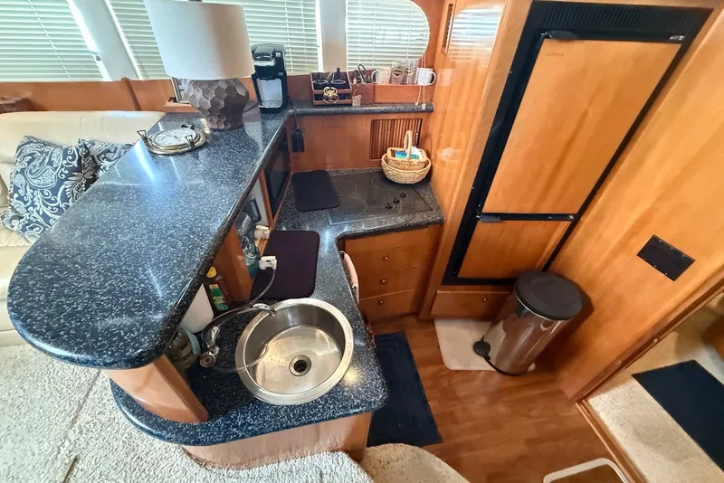 Slide: The Image of Interior of 2000 Carver 396 Motor Yacht kitchen with sink, countertop, and refrigerator. - 21