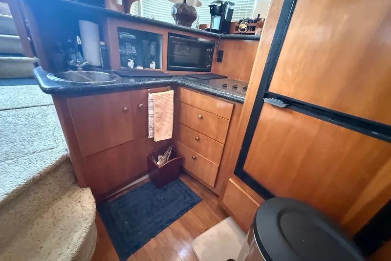Slide: The Image of Compact kitchen area in a 2000 Carver 396 Motor Yacht with wooden cabinetry. - 26