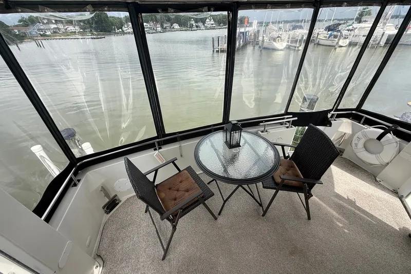 Slide: The Image of Enclosed deck of 2000 Carver 396 Motor Yacht with table and chairs overlooking marina. - 5