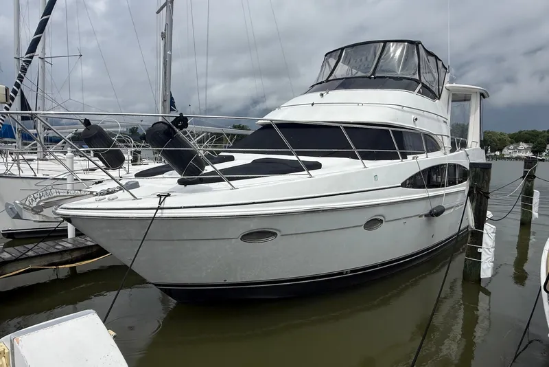 The Image of 2000 Carver 396 Motor Yacht docked at marina under cloudy skies. - 0