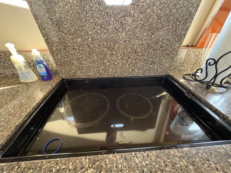Slide: The Image of Kitchen area with a modern built-in cooktop and granite countertops. - 45