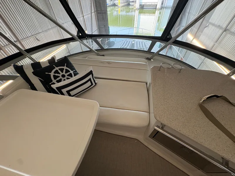 Slide: The Image of Interior of a 2008 Sea Ray 47 Sedan Bridge with white seating and nautical-themed pillows. - 9