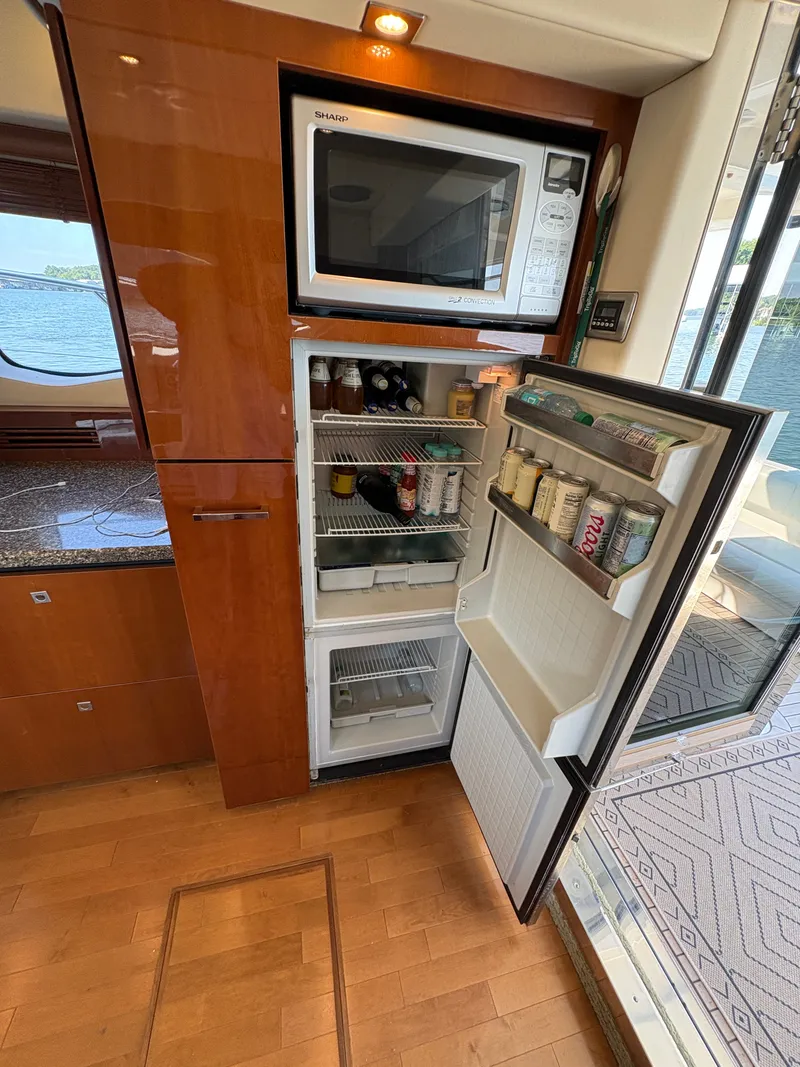 Slide: The Image of The galley of a 2008 Sea Ray 47 Sedan Bridge features an open fridge and a microwave. - 40