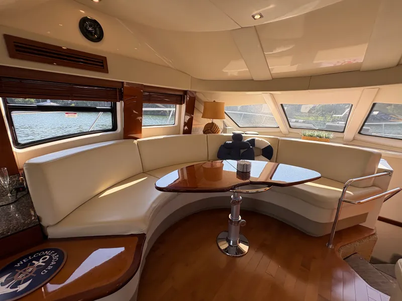 Slide: The Image of Interior of a 2008 Sea Ray 47 Sedan Bridge with elegant seating area and wooden table. - 38