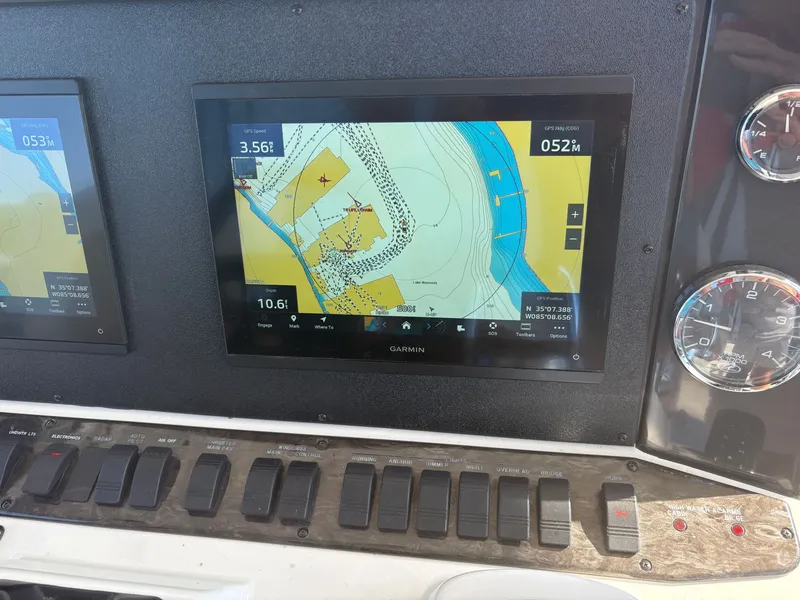 Slide: The Image of The image shows a boat's navigation system with a digital map and multiple switches. - 22