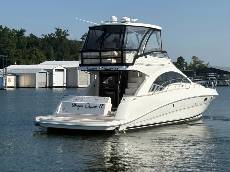 Slide: The Image of 2008 Sea Ray 47 Sedan Bridge on calm water, featuring a covered helm and sleek white exterior. - 5