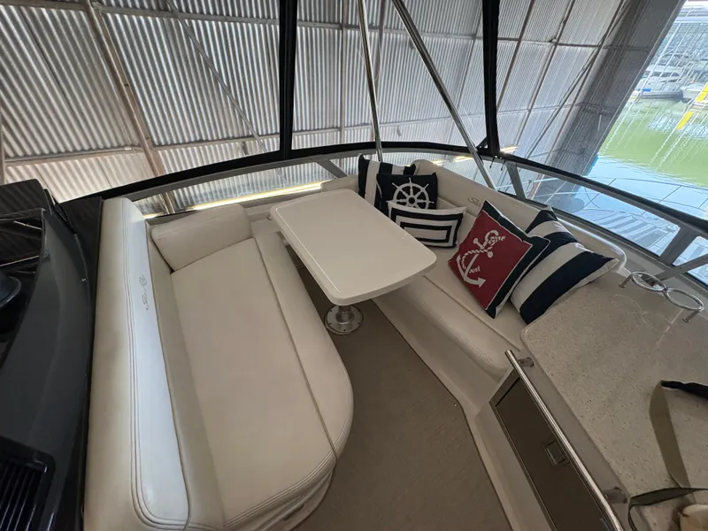 Slide: The Image of Interior of a 2008 Sea Ray 47 Sedan Bridge with white sofa and table. - 8