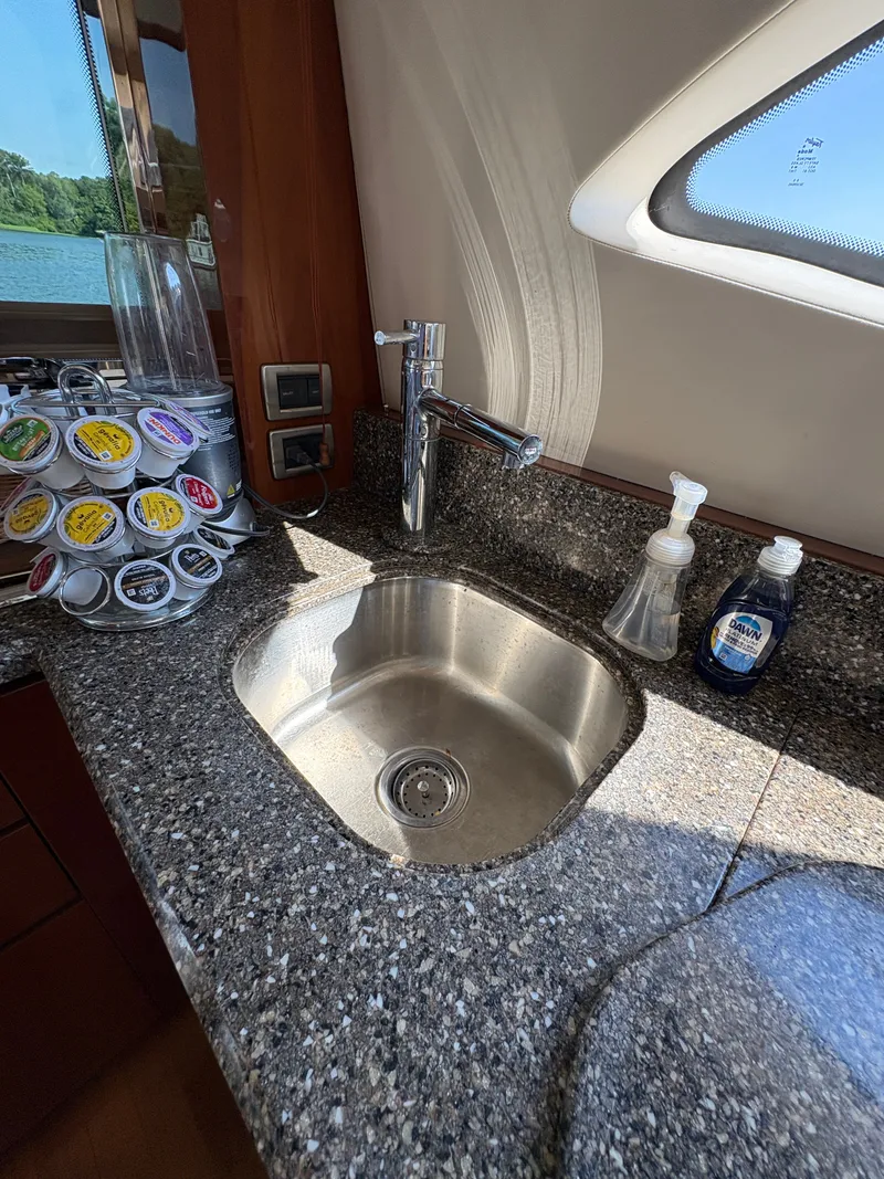 Slide: The Image of Galley area with sink and coffee pods on a Sea Ray 47 Sedan Bridge. - 44