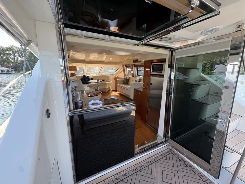 Slide: The Image of Interior view of a 2008 Sea Ray 47 Sedan Bridge with elegant furnishings and large windows. - 48