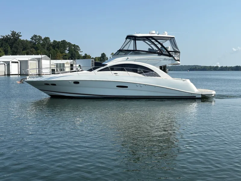 Slide: The Image of 2008 Sea Ray 47 Sedan Bridge on calm water near docks. - 3