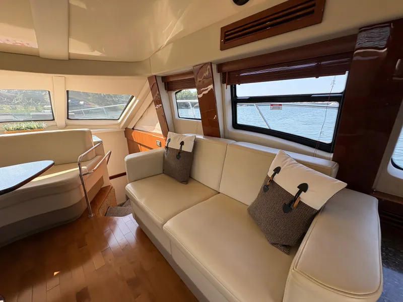 Slide: The Image of Interior of a 2008 Sea Ray 47 Sedan Bridge with beige sofa and large windows. - 37