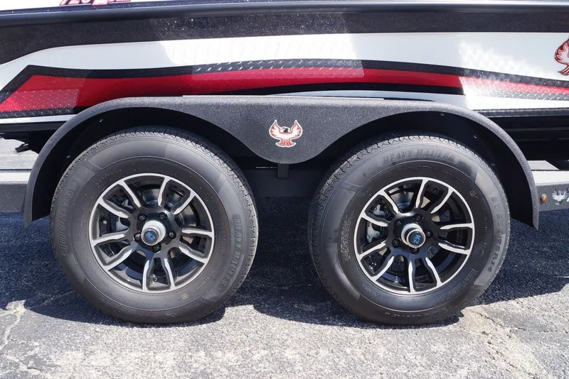 Slide: The Image of Trailer wheels of a 2027 Phoenix 720 ZXL boat, featuring stylish rims and logo. - 8