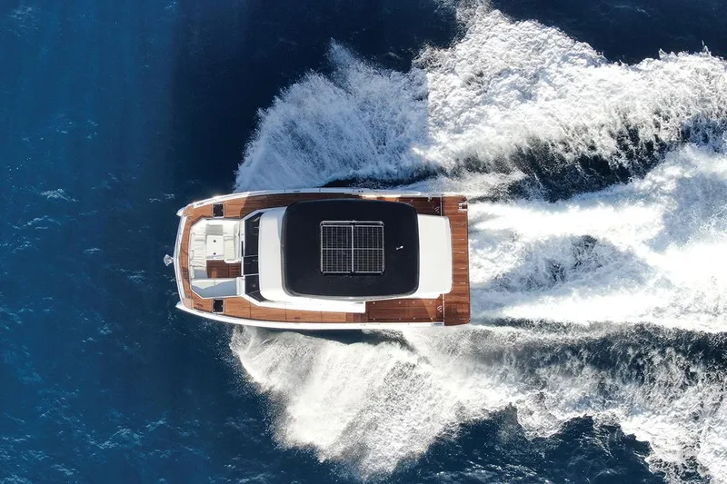 Slide: The Image of Aventura 38 Motor Yacht 2026 cruising on open blue sea, aerial view. - 9