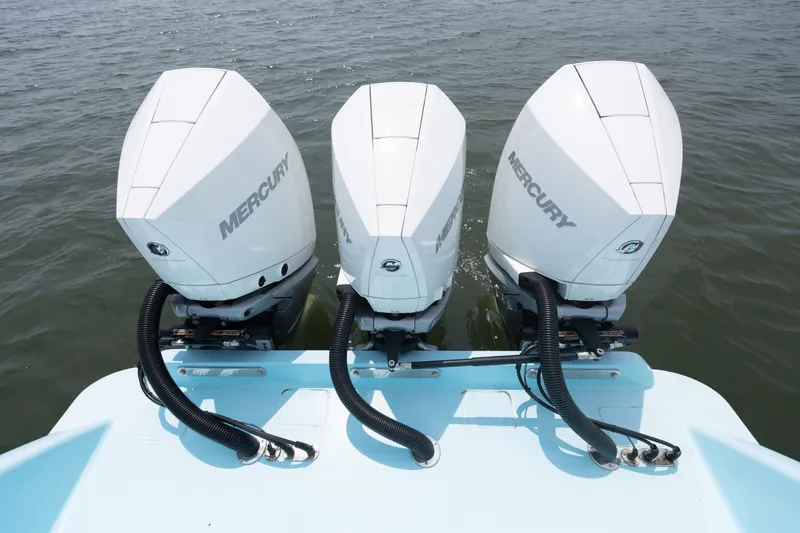 Slide: The Image of Three Mercury outboard engines on a boat in the water. - 47