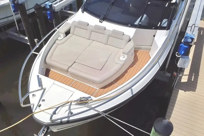 Slide: The Image of 2024 Skamander 100 Sorrento boat with cushioned seating and wooden deck at dock. - 43