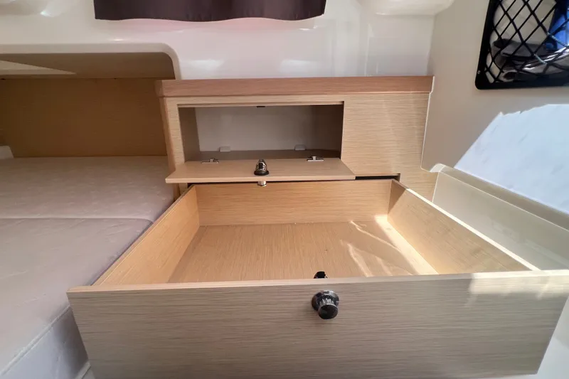 Slide: The Image of Interior storage compartment in 2024 Skamander 100 Sorrento boat, featuring wooden finish and secure locks. - 188