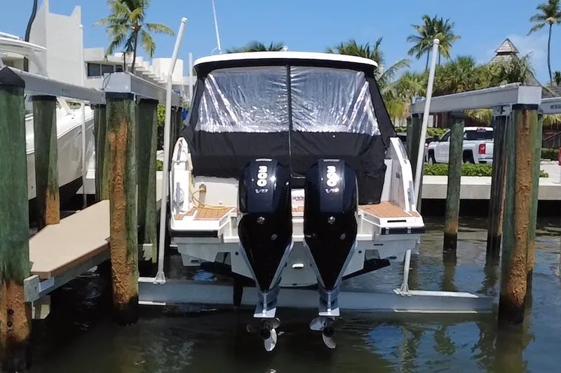 Slide: The Image of 2024 Skamander 100 Sorrento boat docked with dual 300 V8 engines, surrounded by palm trees. - 19