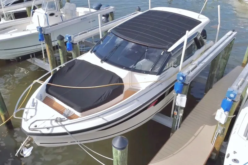 Slide: The Image of 2024 Skamander 100 Sorrento boat docked at marina, covered and elevated. - 1
