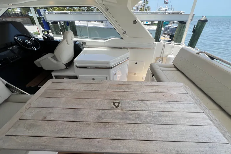 Slide: The Image of 2024 Skamander 100 Sorrento yacht interior with helm, seating, and wooden table. - 162