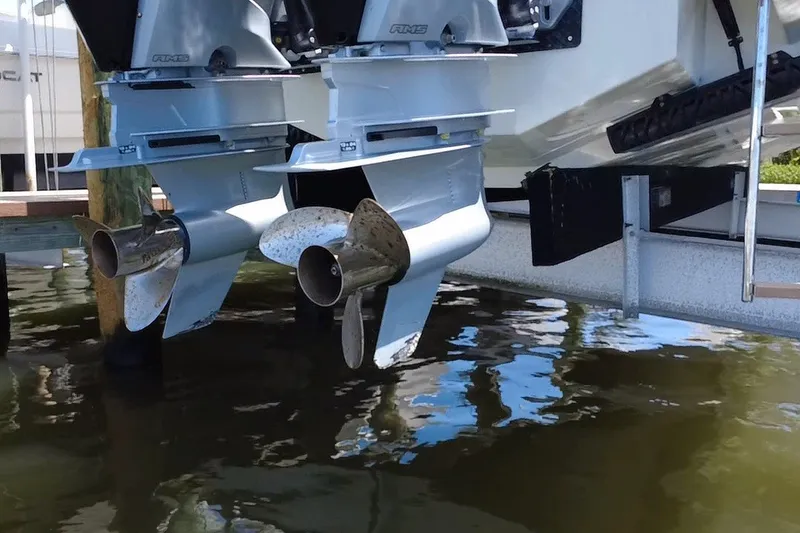 Slide: The Image of Twin outboard motors on a 2024 Skamander 100 Sorrento boat, partially submerged in water. - 6